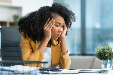 A young African American woman with Afro brown hair in a modern office experiencing panic,...