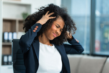 A young African American woman with Afro brown hair in a modern office experiencing panic,...