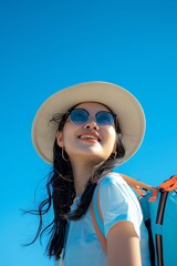 A joyful young Asian tourist woman, donning a straw beach hat, stylish sunglasses, and a backpack filled with adventure essentials,