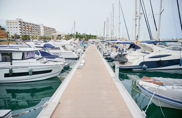 Modern access and floating dock where yachts and sailboats are docked in the marina port in the...