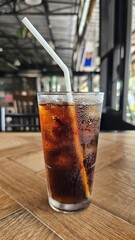 a glass of cola with ice on the table, a cold drink in a hot weather, summer