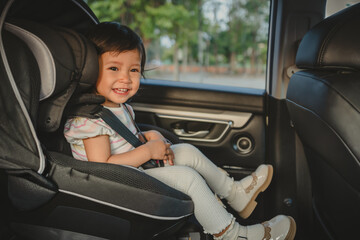 happy toddler girl sitting in car seat, safety baby chair travelling