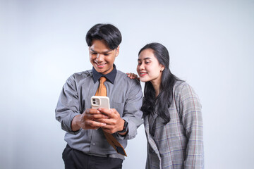 Potrait Of Two Young Businessman And Businesswoman Excited Looking at Smartphone Isolated On White Background