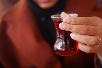 woman drinking Traditional turkish tea on white table .