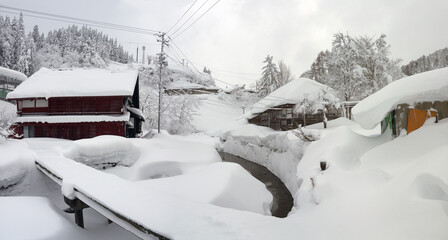 Beautiful Japanese winter rural scenery, small village with traditional houses, big snowdrifts on...