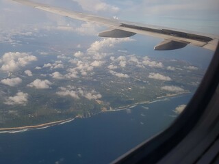 Looking through window aircraft during flight in wing with a nice blue clear sky and beautiful...