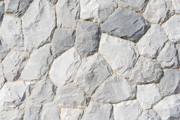 Full frame of natural stone wall. Rock background texture, wall background, stone, abstract. A beautiful stone wall constructed from grey stones.