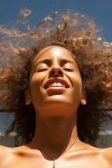 Joyful woman with curly hair enjoying the sun