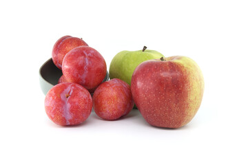 Red plums and green apple isolated on white background