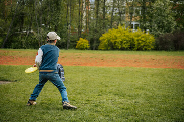 A boy throws disc golf. A young boy learns to throw a discus