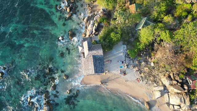 aerial view of a paradisiacal beach with palm trees and boats sailing in the crystal clear waters.
