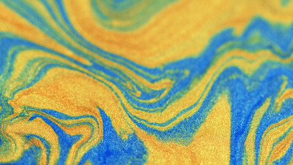 Ink glitter. Liquid sparkles. Yellow colored particles motion down blue painted sand strips...