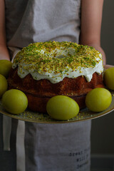 child holding a plate with Easter cake and eggs
