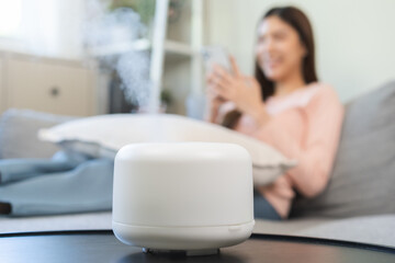 Modern air humidifier, happy asian young woman, girl using smartphone, enjoy aromatherapy steam...