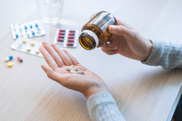 Sick ill asian young woman, girl hold tablet pill on hand pour capsule from medication bottle,...