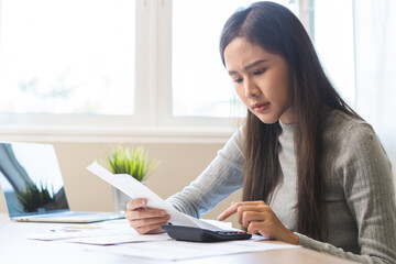 Business financial concept, owe asian young woman sitting stressed, hand calculate expense, cost or...