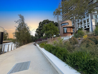 Parramatta River walkway lined with trees Ferry Wharf and High rise residential appartments on...
