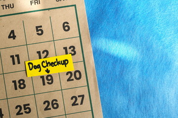 Dog checkup schedule concept. Written reminder note on calendar.	