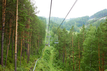 Chairlift to the top of the mountain. Beautiful summer forest landscape. Ski resort