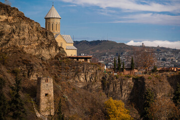rugged beauty of Tbilisi's landscape featuring prominent church ancient tower perched on cliff...