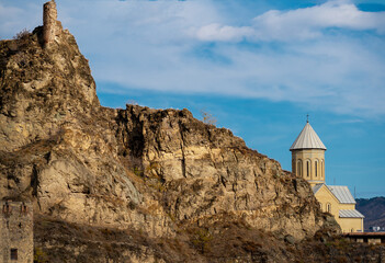 ruins of an old fortress and a Georgian church on a rocky hillside in Tbilisi emphasizes the...