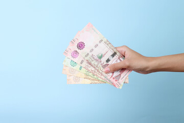 Woman hands holding Saudi Arabia money isolated on blue background