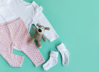 Set of baby bodysuits, pants, socks and knitted toy