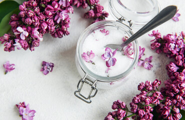 Lilac sugar in glass jar and fresh flowers