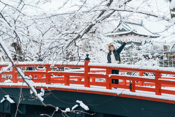 Woman tourist sightseeing Hirosaki Castle in winter, happy traveler travel Hirosaki city, Aomori...