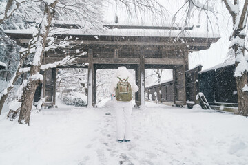 Woman tourist sightseeing Yamadera temple with snow in winter, traveler travel Risshakuji temple in Yamagata City, in Yamagata Prefecture, Tohuku, Japan. Landmark for tourists attraction in Japan