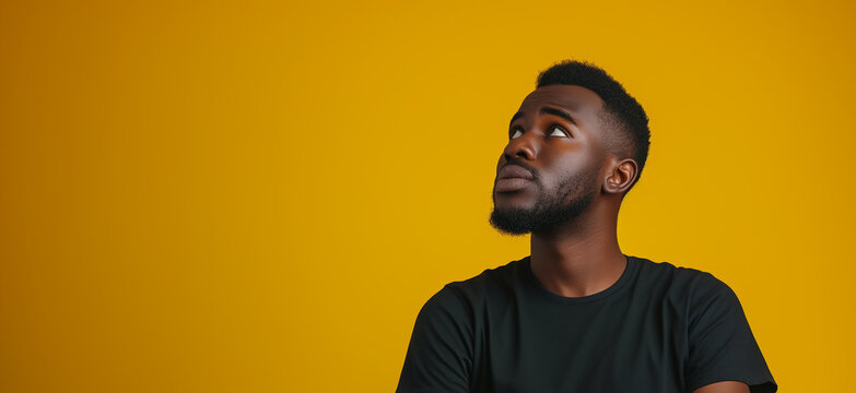 Contemplative African American Man in Black Top T-Shirt Pondering with Tablet, Isolated on Vibrant Yellow Background - Concept of Confusion, Decision Making, Technology, and Diversity