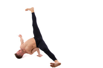 A handsome young man with an athletic body is doing fitness and yoga. White background.