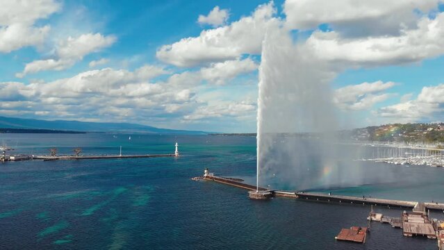 cinematic aerial pan around video of the geneva water fountain in switzerland during a hot and sunny day by the water in the middle of the day.