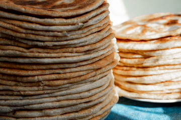 Flatbread lavash, chapati, naan, heap of tortilla on a blue background Homemade flatbread stacked.
