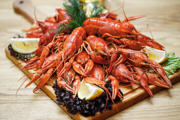 a pile of cooked lobsters on a wooden board