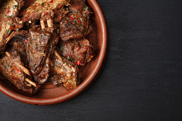 a plate of meat on a black surface