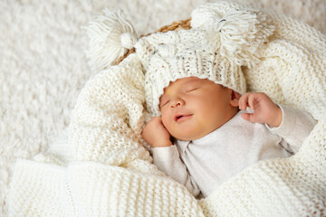 Baby smile in Sleep. Smiling Newborn sleeping on White Blanket in Cradle. Happy Little Child Face...