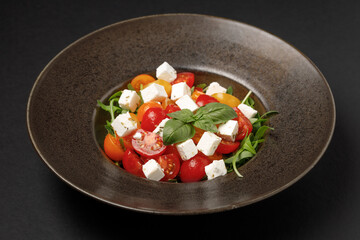 a bowl of salad with tomatoes and cheese