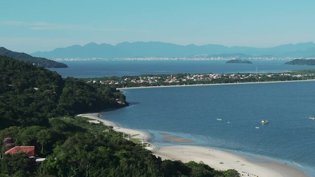 A rotating aerial image captures the picturesque Forte Beach with Daniela Beach in the background.