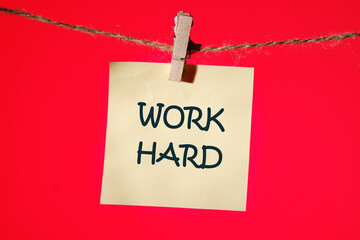 Work Hard It is written on a yellow sticker on a red background
