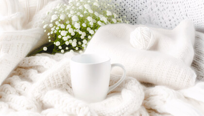 a cozy scene with a white ceramic mug placed among a soft, textured background of white