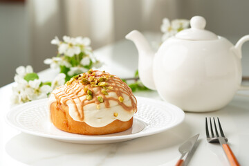 Cinnamon roll bun with icing on plate