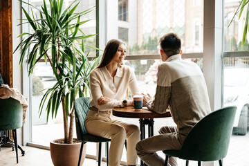 Couple Engaged in Conversation at a Cozy Cafe During Daytime