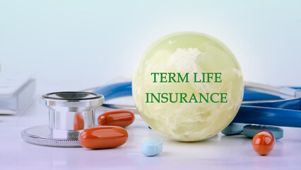 Medical concept. TERM LIFE INSURANCE on the balloon next to medical paraphernalia and pills