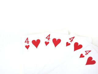 Close-up of four identical poker cards with the four of hearts isolated on a white background and...