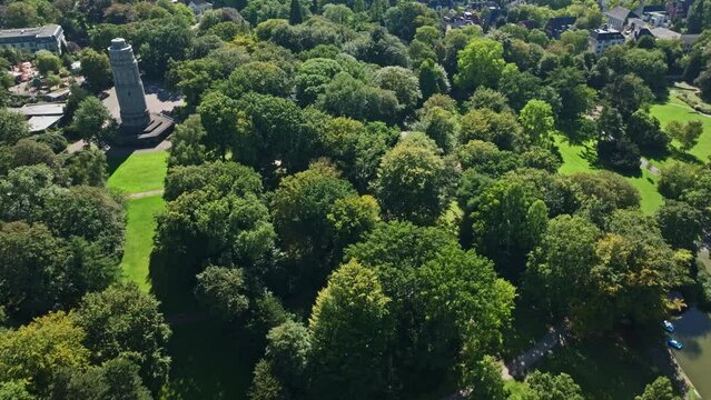 Aerial drone view of Bochum Park, also known as Stadtpark Bochum, featuring Fossilium Bochum Zoo. This spacious green space includes a boating pond and a zoo, offering a delightful blend of nature .