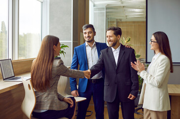 Business people shaking a hand as formal greeting, congratulation, agreement or farewell. Workers...
