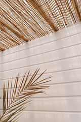 Palm leaf and straw thatch with sunlight shadows. Boho style background