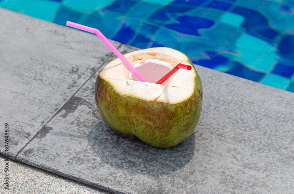 Wall mural Coconut with a straw near the pool