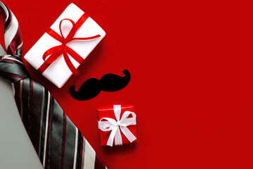 Happy Father's Day. Top view of necktie,gift boxes with red bow and false mustache with copy space...
